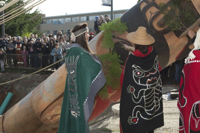 The Reconciliation totem pole carved by James Hart (7idansuu), Haida master carver and Hereditary Chief is purified by first nations women with cedar boughs before being erected on the Main Mall at the University of British Columbia in Vancouver in 2017. The totem pole represents survivors of Canada's residential school system. File Photo by Heinz Ruckemann/UPI