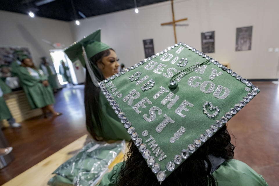 The mortar cap of Mariah Wright, 16, says "I did my best; God did the rest!" as she stands next to salutatorian Alasia Baker, 17, before a graduation ceremony for Springfield Preparatory School at Victory in Christ church in Holden, La., Saturday, Aug. 5, 2023. Nearly 9,000 private schools in Louisiana don’t need state approval to grant degrees. Non-approved schools make up a small percentage of the state total. But the students in Louisiana’s off-the-grid school system are a rapidly growing example of the national fallout from COVID-19 — families disengaging from traditional education. (AP Photo/Matthew Hinton)
