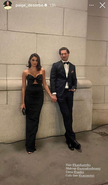 Paige DeSorbo and Craig Conover posing in black outfits in front of a brick wall.