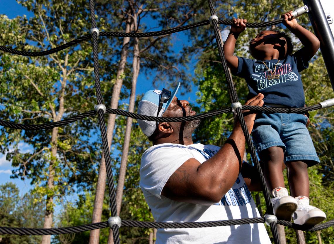 Atari Thomas helps Bryson climb a ropes tower at Barwell Road Park.