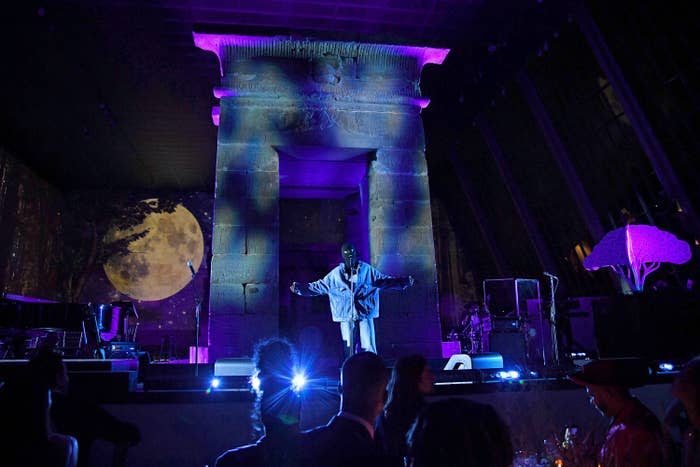 Justin Beiber wears a balaclava as he performs inside the Met Gala with a projection of a full moon in the background