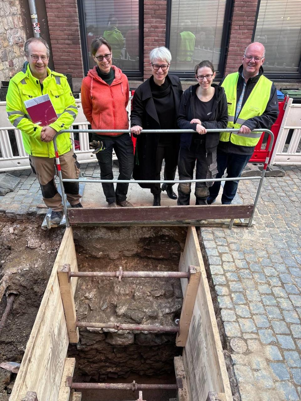 Archaeologists stand above the 1,700-year-old Roman wall.