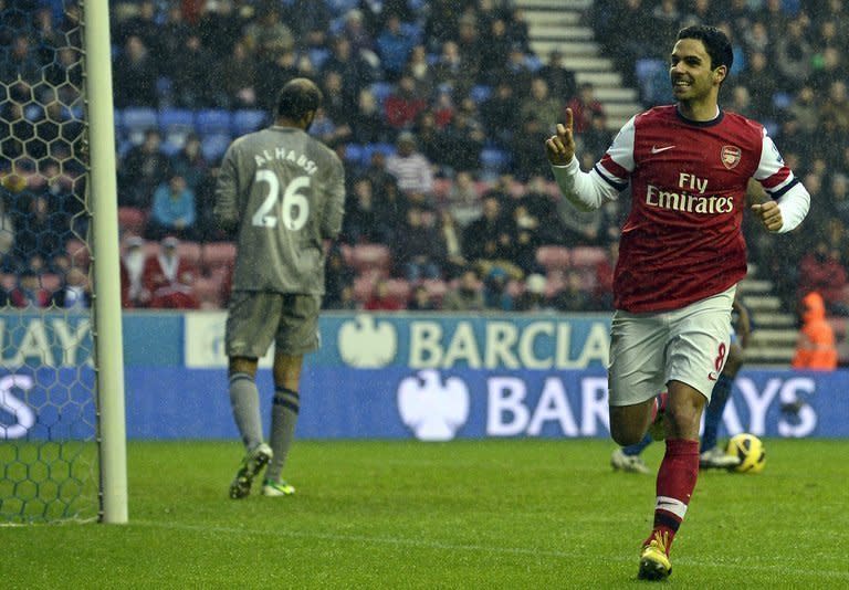 Arsenal's Mikel Arteta (R) celebrates after scoring during the Premier League match against Wigan on December 22, 2012. Arsenal climbed to third place in the Premier League as Arteta's second half penalty sealed a 1-0 win over Wigan