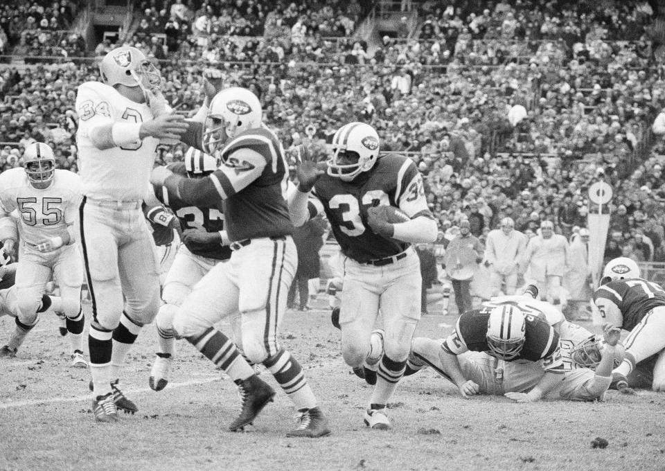 File-This Dec. 6, 1970 file photo shows New York Jets running back Emerson Boozer (32) goes for a three-yard gain in the second quarter at New York's Shea Stadium as Jets' tight end Pete Lammons fends off Oakland Raiders' linebacker Gus Otto (34). Lammons, a tight end on the New York Jets' Super Bowl-winning team in 1969, has died in a boating accident. He was 77. Major League Fishing announced in a statement Friday, April 30, 2021, that Lammons was participating in a fishing event on the Sam Rayburn Reservoir in Texas on Thursday morning when he slipped while boarding a boat, fell into the water, and drowned. (AP Photo/Harry Harris, File)