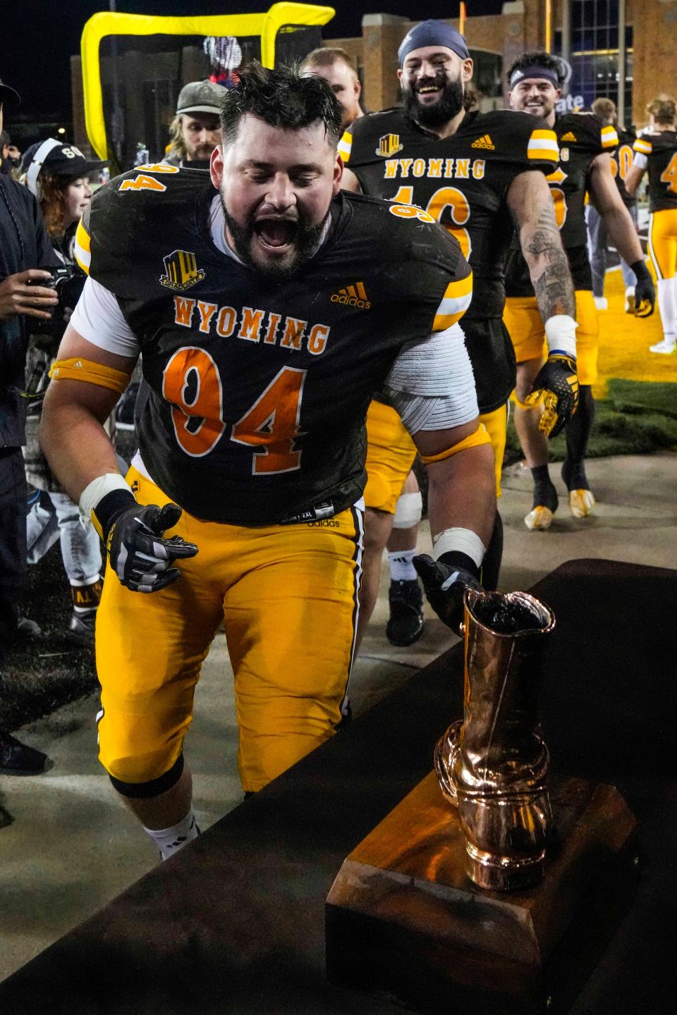 Nov 3, 2023; Laramie, Wyoming, USA; Wyoming Cowboys nose guard Cole Godbout (94) gets to the Bronze Boot traveling trophy after a victory over the Colorado State Rams at Jonah Field at War Memorial Stadium. Mandatory Credit: Troy Babbitt-USA TODAY Sports