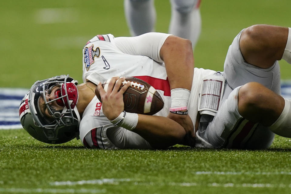 Ohio State quarterback Justin Fields grimaces after getting hit by Clemson linebacker James Skalski during the first half of the Sugar Bowl NCAA college football game Friday, Jan. 1, 2021, in New Orleans. Skalski was ejected from the game for targeting. (AP Photo/Gerald Herbert)