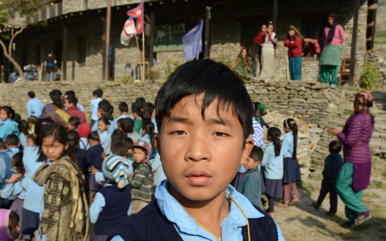 Nepalese school student Dawa Phunchok Lama poses in front of the Shree Buddha Secondary School in the village of Sirdibas in Gorkha District