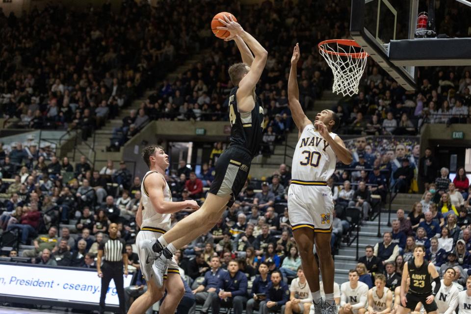 Army's Matt Dove dunks over Navy's Mike Woods late in the first half on Saturday. Navy prevailed 77-71. ALLYSE PULLIAM/For the Times Herald-Record