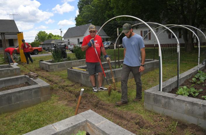 Taylor Henry, right, Director of Gardening, talks with Joe Garner during a LOT Project garden work day with Keller Williams volunteers, in Anderson, S.C. Thursday, May 12, 2022. 