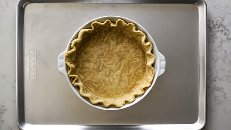 pie crust in pie pan on baking sheet