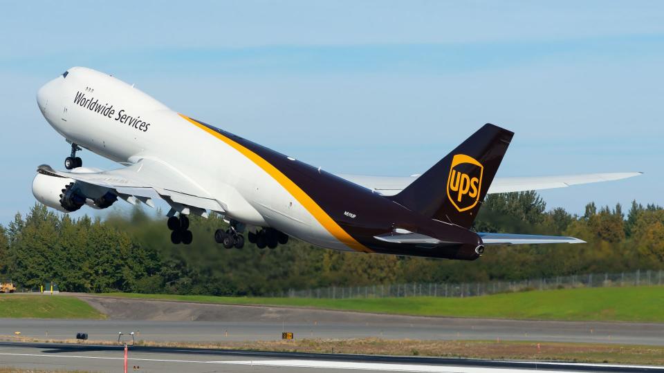 A brown-tail UPS jumbo jet takes off on a clear day.