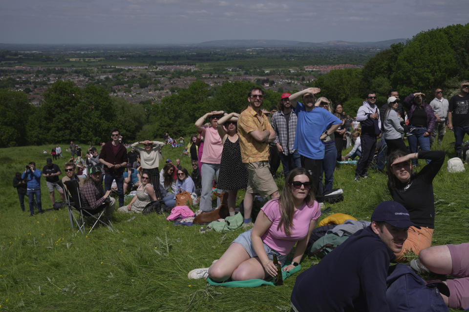 Visitors watch the Cheese Rolling contest at Cooper's Hill in Brockworth, Gloucestershire, Monday May 29, 2023. The Cooper's Hill Cheese-Rolling and Wake is an annual event where participants race down the 200-yard (180 m) long hill chasing a wheel of double gloucester cheese. (AP Photo/Kin Cheung)