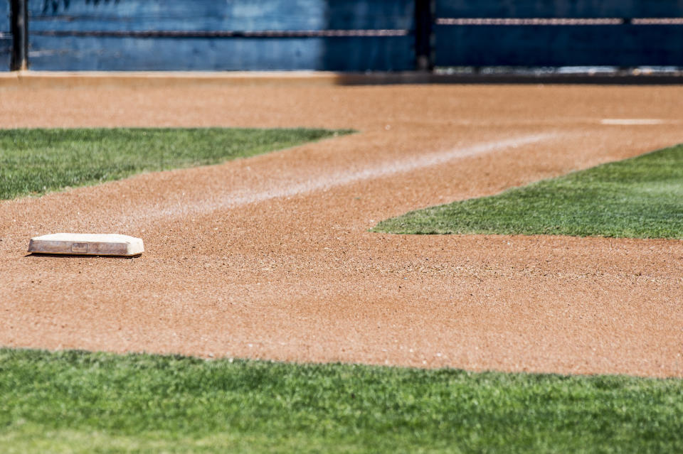 first base with home plate in background isolated on an empty baseball diamond