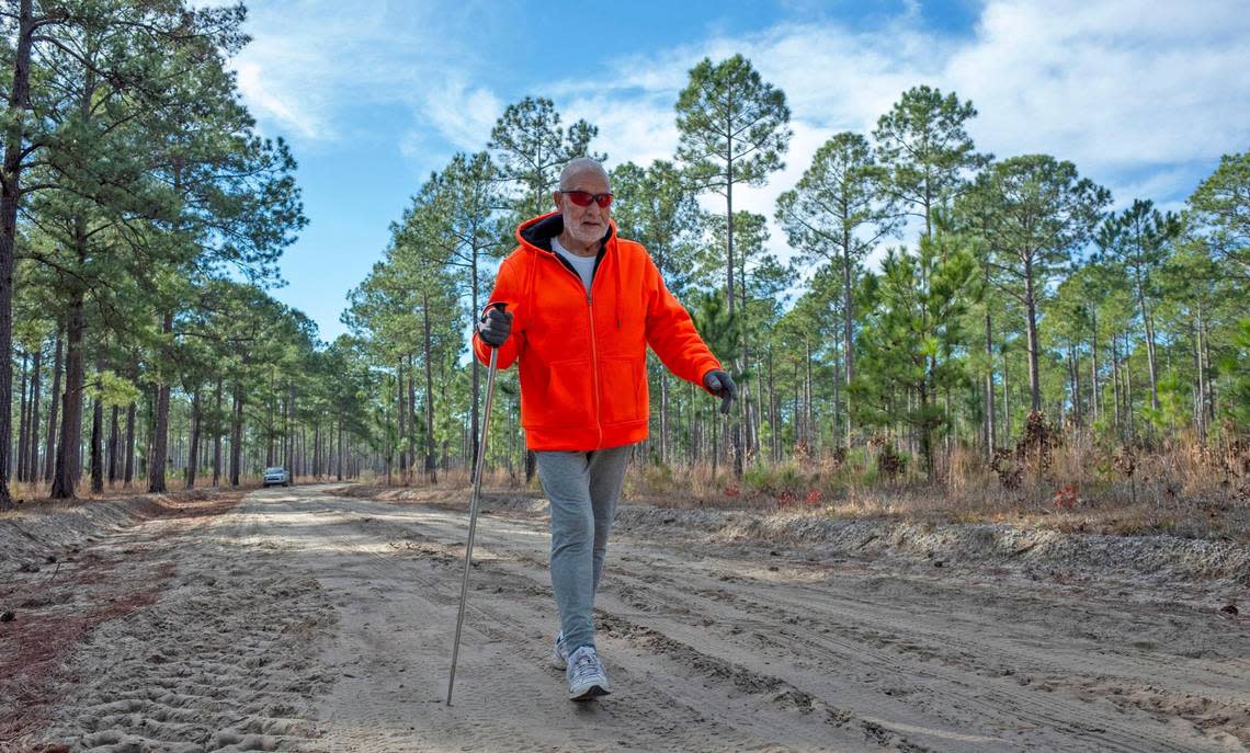 Frank Sousa, wearing orange as required to alert hunters, walks the dirt roads of the Lewis Ocean Bay Heritage Preserve near Myrtle Beach, S.C. January 10, 2023.