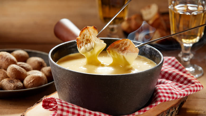 Dipping food in fondue-slash-fonduta bowl 