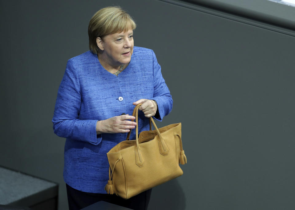 German Chancellor Angela Merkel holds her bag as she arrives for a meeting of the German federal parliament, Bundestag, at the Reichstag building in Berlin, Germany, Wednesday, Sept. 11, 2019. (AP Photo/Michael Sohn)