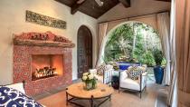 A massive pink fireplace is the main feature of the outdoor space, which is surrounded by draping curtains and European-style furniture.