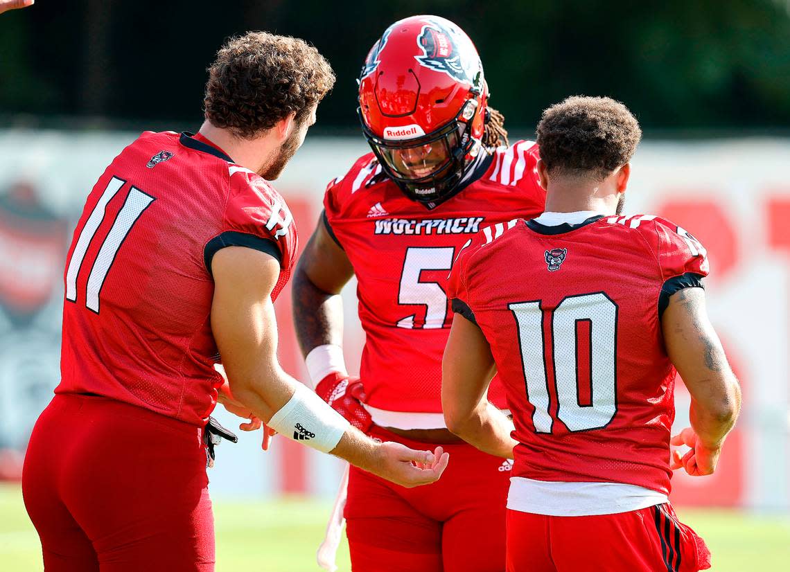 N.C. State defensive tackle C.J. Clark (5) laughs with Payton Wilson (11) and Tanner Ingle (10) during the Wolfpack’s first practice of fall camp in Raleigh, N.C., Wednesday, August 3, 2022.