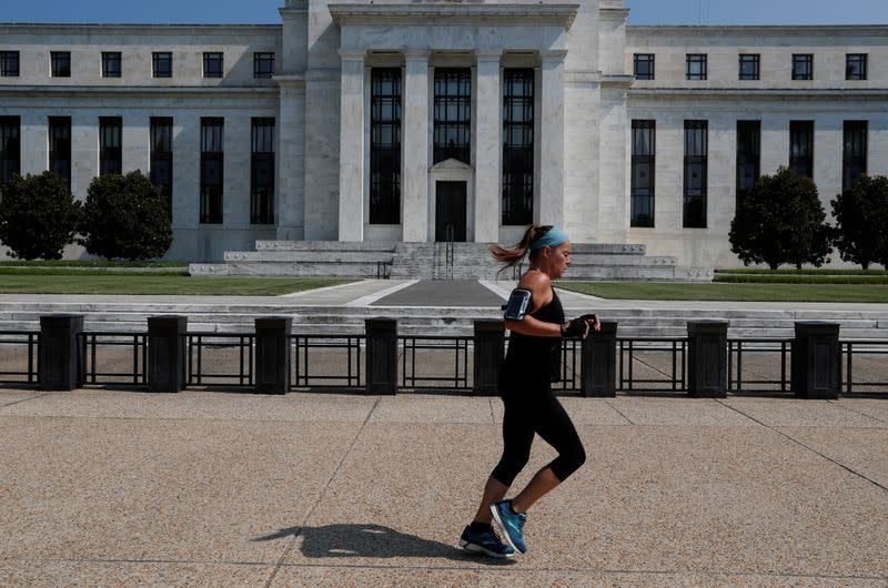 FILE PHOTO: Woman jogs past the Federal Reserve building in Washington