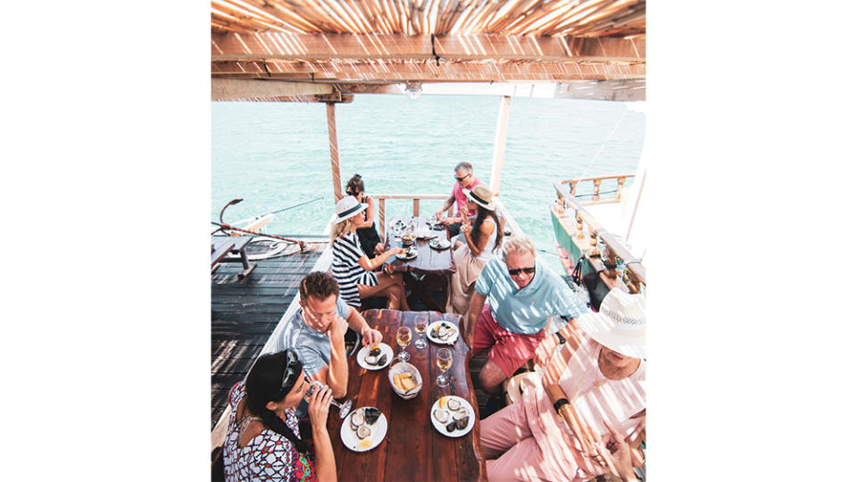 Oysters and wine on a floating dock, with the shellfish harvested from the surrounding waters. - Credit: William Tortillo