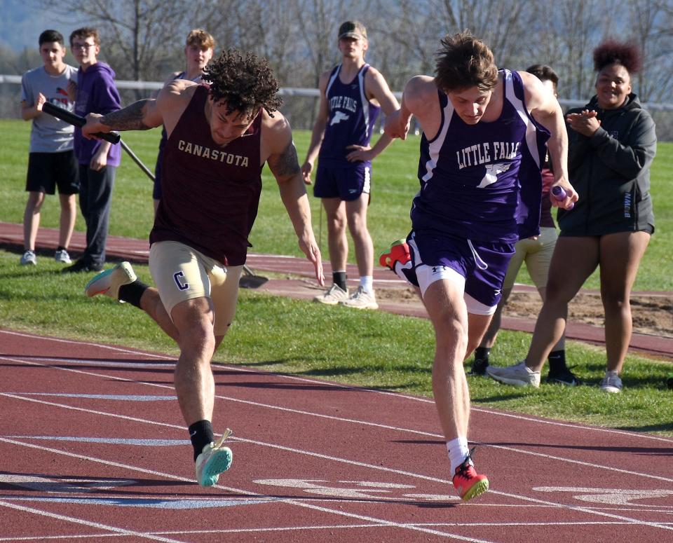 Canastota Raider Devon Youker and Little Falls Mountie Coltan Frederick (from left) lunge toward the finish line side-by-side at the end of the final leg of the four-by-100-meter relay Tuesday.