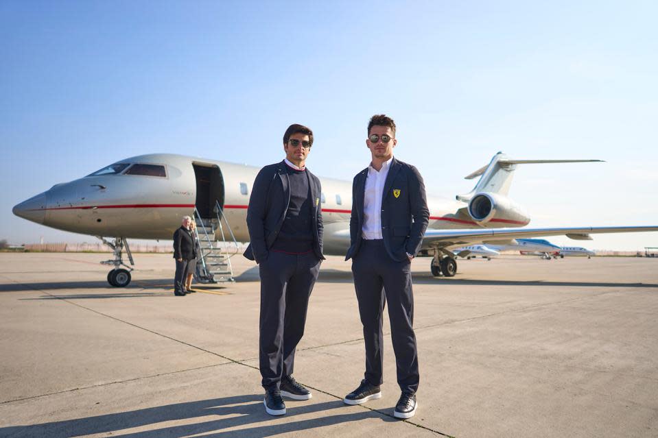 Los pilotos de Ferrari F1 Carlos Sainz y Charles Leclerc parados frente a un jet privado VistaJet