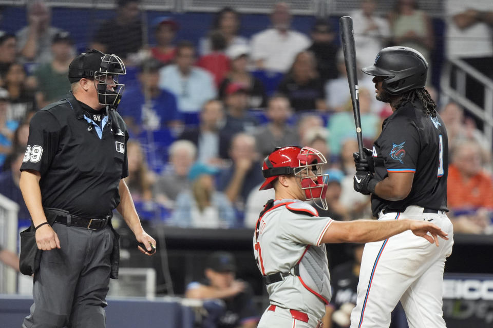 Miami Marlins' Josh Bell, left, has words with home plate umpire Cory Blaser after striking out looking during the first inning of a baseball game against the Philadelphia Phillies, Friday, May 10, 2024, in Miami. (AP Photo/Wilfredo Lee)