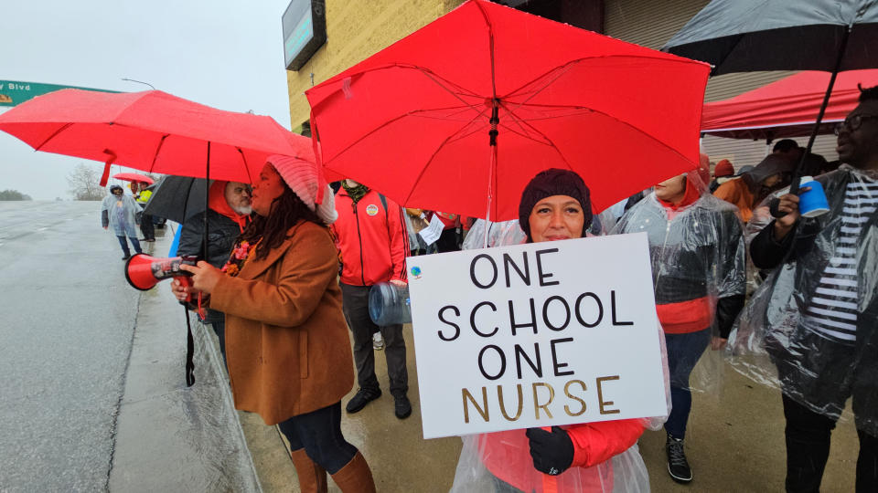 A school nurse joins Los Angeles Unified School District teachers and Service Employees International Union 99 (SEIU) members rally under heavy rain outside the Edward R. Roybal Learning Center in Los Angeles, Tuesday, March 21, 2023. Tens of thousands of workers in the Los Angeles Unified School District walked off the job Tuesday over stalled contract talks, and they were joined by teachers in a three-day strike that shut down the nation’s second-largest school system. (AP Photo/Damian Dovarganes)