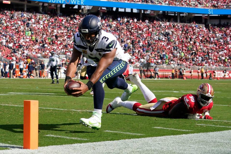 Seattle Seahawks quarterback Russell Wilson (3) runs for a touchdown past San Francisco 49ers defensive tackle Javon Kinlaw (99) during the second half of an NFL football game in Santa Clara, Calif., Sunday, Oct. 3, 2021. (AP Photo/Tony Avelar)