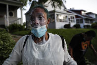 A protestor douses her face with milk after being exposed to tear gas fired by police, Thursday, May 28, 2020, in St. Paul, Minn. Protests over the death of George Floyd, a black man who died in police custody Monday, broke out in Minneapolis for a third straight night. (AP Photo/John Minchillo)