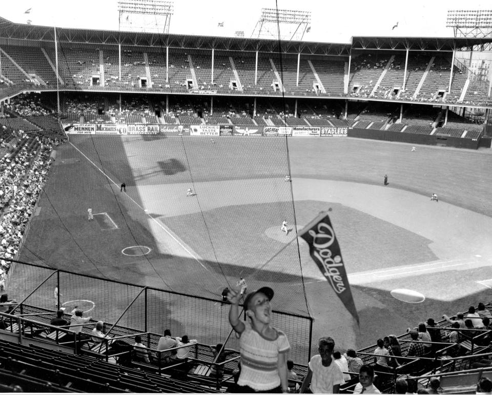 FILE - In this file photo of Sept. 22, 1957, two days before the Brooklyn Dodgers played their last game at Ebbets Field, a young Dodgers fan waves a banner in the stadium as the Dodgers played the Philadelphia Phillies in Brooklyn, N.Y. It was like a death in the family for Brooklyn baseball fans when their beloved Dodgers left the borough behind for the California coast. But after decades without a professional sports team, Brooklyn is hitting the major leagues again on Friday, Sept. 21, 2012 when the Brooklyn Nets’ new arena opens to the public. (AP Photo/File)
