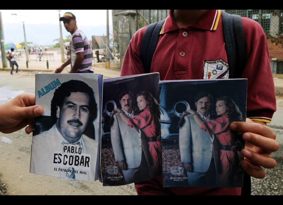 Youths show the three magazines they bought about the life of the late Colombian drug trafficker Pablo Escobar outside a small food store where they made the purchase in the neighborhood Comuna Nororiental 1 in Medellin, Colombia, Wednesday, Aug. 8, 2012. The magazine, whose publisher is unknown, comes with blank pages with instructions to fill them with small photographs which are bought separately, like baseball cards, at several small stores in the neighborhood. The cards showing images of Escobar, are a mix of real life photos and of actors playing out his life from a local TV series called "Escobar, El Patrón del Mal." (AP Photo/Luis Benavides)