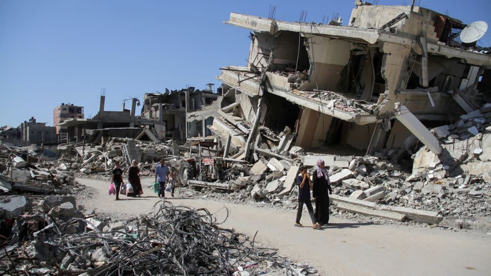 Palestinians walk among the rubble of damaged buildings, which were destroyed during Israel's military offensive, in Beit Lahia in the northern Gaza Strip on June 12, 2024. - Mahmoud Issa/Reuters