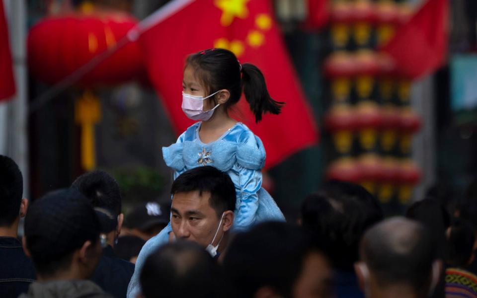China father and daughter with Chinese flag - AP Photo/Mark Schiefelbein, File