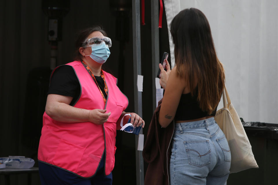 A woman shows a another woman her phone to gain entrance into a building.