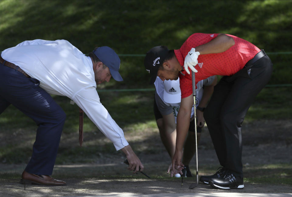 Xander Schauffele of the United States, right, places his ball after dropping it near the first green during the first round of the WGC-Mexico Championship golf tournament, at Chapultepec Golf Club in Mexico City, Mexico City, Thursday, Feb. 20, 2020.(AP Photo/Fernando Llano)