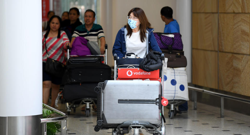 Passengers wearing protective masks arriving at Sydney International Airport on January 23, 2020, amid the threat of coronavirus.
