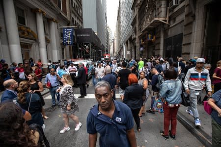 Commuters are seen on Fulton Street after the Fulton Street subway station was closed as police investigated two suspicious packages in Manhattan