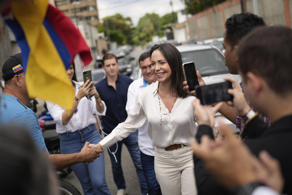 Supporters greet opposition presidential hopeful Maria Corina Machado as she arrives at a polling station to cast her ballot during the opposition primary election in Caracas, Venezuela, Sunday, Oct. 22, 2023. The opposition will pick one candidate to challenge President Nicolás Maduro in 2024 presidential elections. (AP Photo/Matias Delacroix)