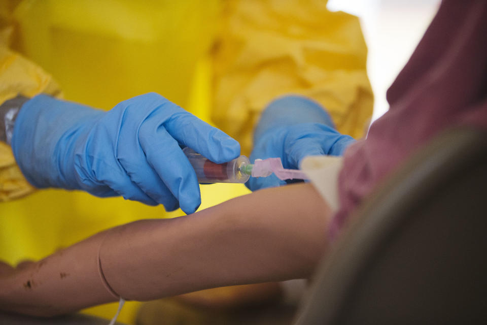 Licensed clinician Hala Fawal practices drawing blood from a patient using a dummy on Monday, Oct. 6, 2014, in Anniston, Ala. The Centers for Disease Control and Prevention (CDC) has developed an introductory training course for licensed clinicians. According to the CDC, the course is to ensure that clinicians intending to provide medical care to patients with Ebola have sufficient knowledge of the disease. (AP Photo/Brynn Anderson)