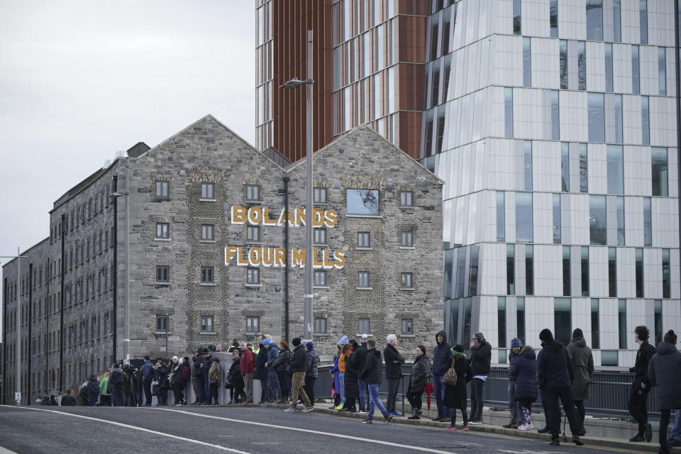 Crowds line the streets by Grand Canal dock as they wait for the funeral procession of Shane MacGowan to make its way through the streets of Dublin ahead of his funeral in Co Tipperary, in Ireland, Friday, Dec. 8, 2023. MacGowan, the singer-songwriter and frontman of The Pogues, best known for their ballad “Fairytale of New York,” died on Thursday, Nov. 30, 2023. He was 65. (Niall Carson/PA via AP)