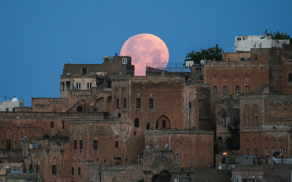 A full moon rises above the historical city center of Mardin, in southeastern Turkey on early Monday - Emrah Gurel/AP