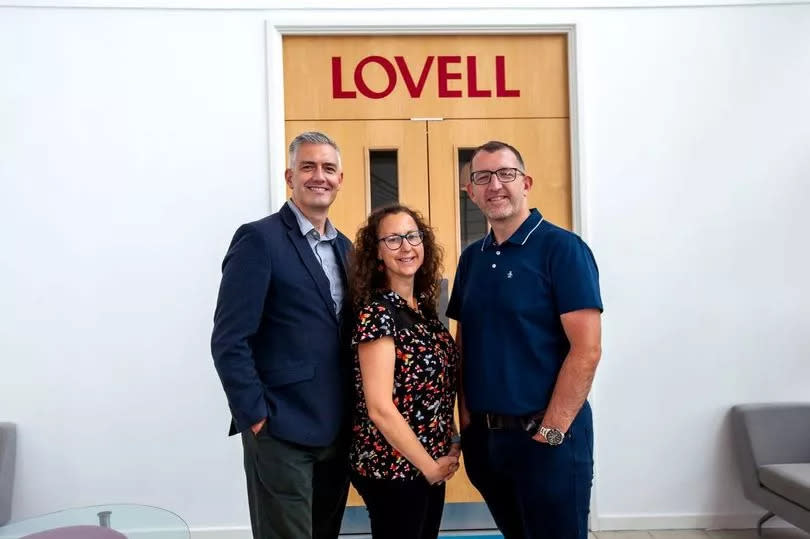 Lovell and Oasis Community Housing staff, posing beside signage.