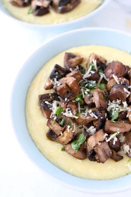 roasted mushrooms on top a bowl of polenta with parmesan cheese