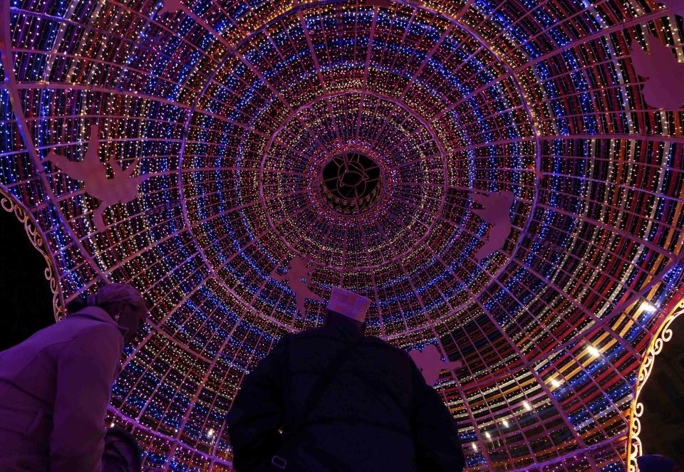 People sit inside a giant Christmas ball as part of Christmas holiday season decorations in Nice