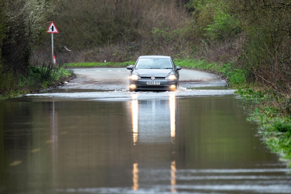 Thorpe Green, Egham, Surrey, UK. 1st April, 2023. A motorist thinks twice before going through flood water and reverses back in Mill House Lane in Thorpe Green Egham, Surrey which remains closed due to flooding. Following heavy rain in the past few days, The Environment Agency issued a Flood Warning today for Chertsey Bourne at Thorpe Green. Maureen McLean/Alamy Live News