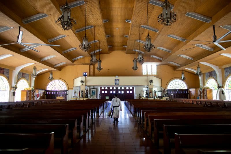 The Wider Image: Hazmat suits and holy water: two priests bring faith to Philippines lockdown