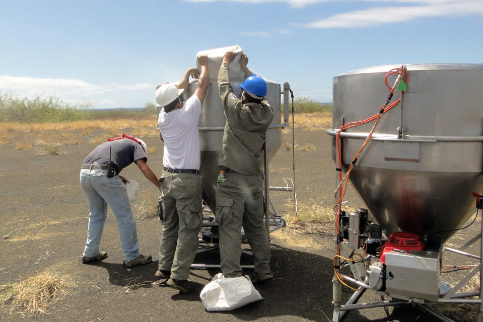 In this Nov. 11, 2012 photo released by Galapagos National Park, park staff test equipment that will hold poisonous bait to kill rats on the Galapagos Islands, as they stand on Baltra Island. To preserve the unique birds, reptiles and native plants that make the Galapagos Islands such an ecological treasure, authorities will start on Wednesday, Nov. 14, 2012 phase II of a mass kill-off of black and Norway rats, an invasive species introduced to the Pacific Ocean islands by whalers and buccaneers beginning in the 17 century. (AP Photo/Galapagos National Park)