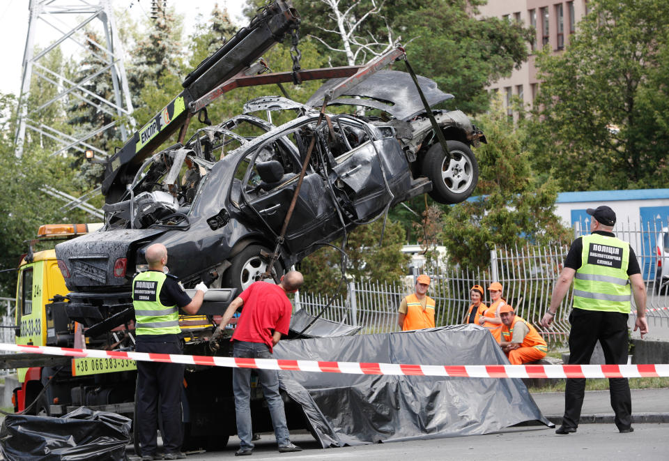 Forensic police experts and military intelligence examine the wreckage of a car in Kyiv. The commander of Ukraine's military intelligence special ops unit colonel Maksym Shapoval was killed by a bomb attached to the bottom of his vehicle in central Kyiv. (Sergii Kharchenko/Pacific Press/LightRocket via Getty Images)