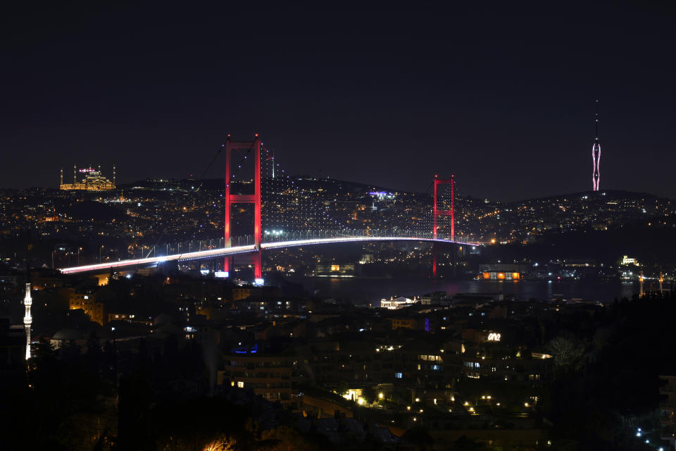 Backdropped by the Camlica mosque, top left, and Camlica tower, cars cross July 15 Martyrs' bridge, center, that connects European and Asian sides of Istanbul, Turkey, Tuesday, March 19, 2024. (AP Photo/Khalil Hamra)